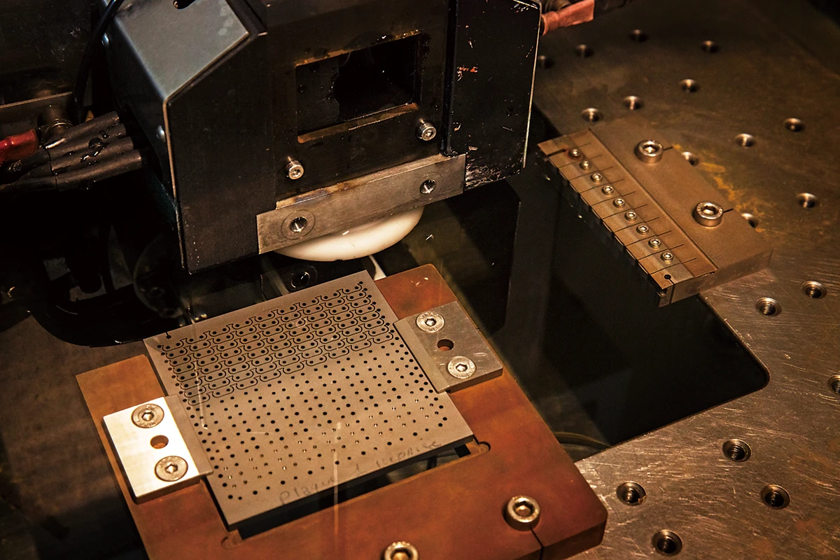 ワイヤ放電加工機でブレスレットのコマを抜く作業